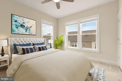 a bedroom with a bed painting on wall and a large window