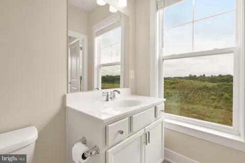 a bathroom with a sink a toilet and a window