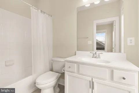a bathroom with a sink toilet vanity and tub