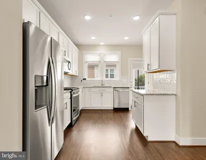a kitchen with white cabinets and stainless steel appliances