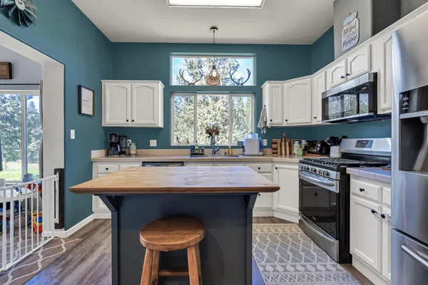 a kitchen with stainless steel appliances granite countertop a stove refrigerator sink and microwave