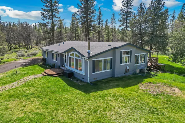 a view of a house with backyard and trees