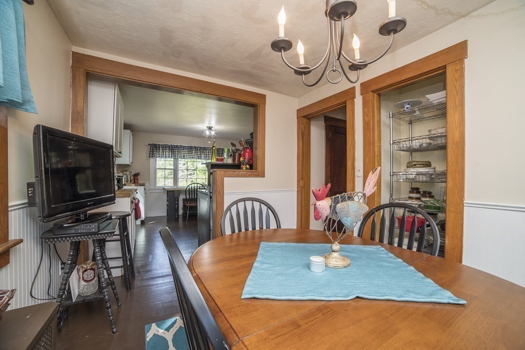 109 Hinsdale Road Northfield, MA 01360 - Photo 11 of 42 a dining room with wooden floor a chandelier a wooden table and chairs