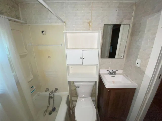 a bathroom with a sink a toilet and mirror