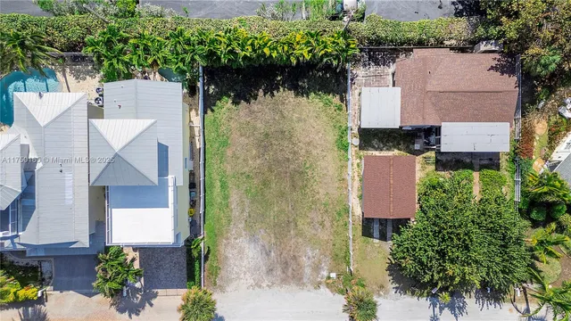 an aerial view of a house with a yard and large trees