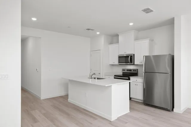 a kitchen with stainless steel appliances a refrigerator stove microwave and sink