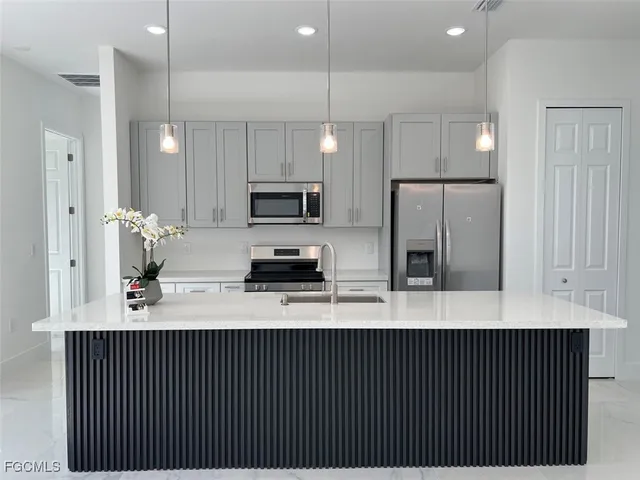 a kitchen with stainless steel appliances a refrigerator sink and microwave