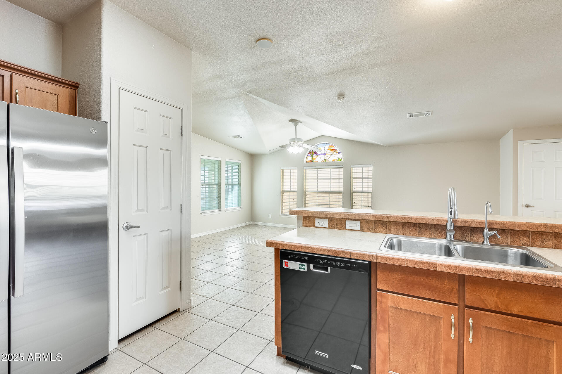 3301 South Goldfield Road, Unit 1043 Apache Junction, AZ 85119 - Photo 32 of 36 a kitchen with granite countertop a sink and a refrigerator