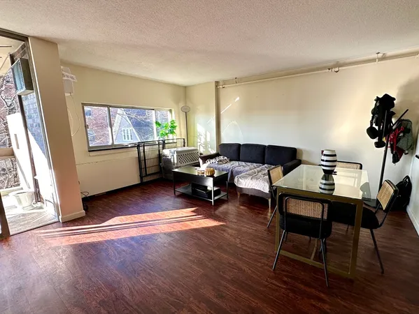 a living room with furniture a window and wooden floor