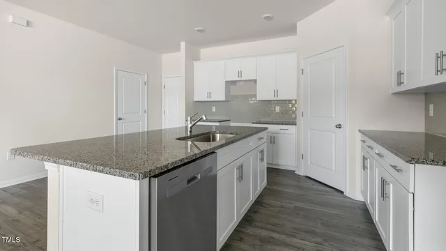 a kitchen with granite countertop a sink and cabinets