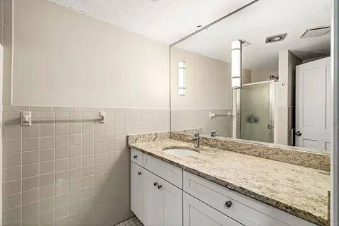 a bathroom with a granite countertop sink and a mirror