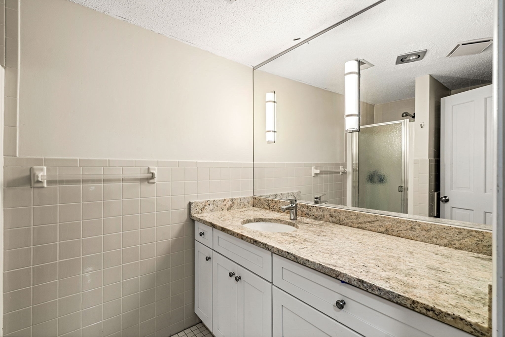 90 Wharf Street, Unit L10 Salem, MA 01970 - Photo 21 of 32 a bathroom with a granite countertop sink and a mirror