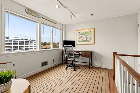 a view of a workspace with furniture and a window