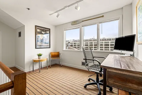 a living room with furniture a flat screen tv and a floor to ceiling window