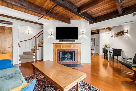 a living room with furniture a flat screen tv and a fireplace