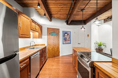 a open kitchen with stainless steel appliances granite countertop a sink a stove and a refrigerator