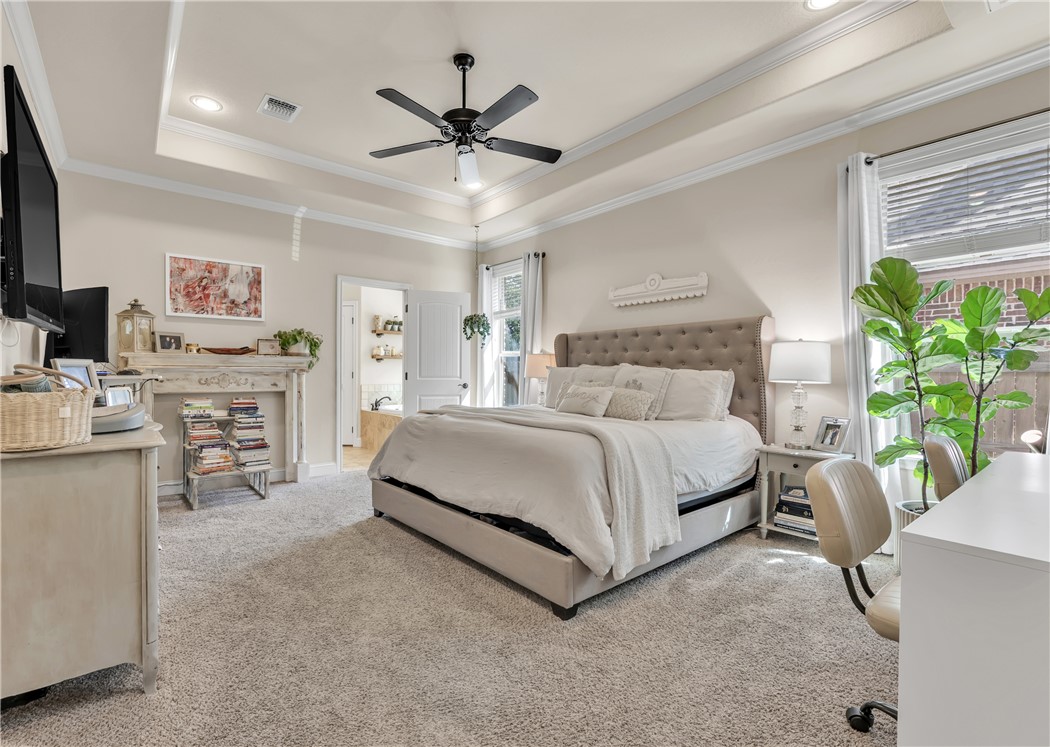 8312 Raintree Drive College Station, TX 77845 - Photo 15 of 30 Spacious bedroom featuring a tray ceiling with crown molding, recessed lighting, and a ceiling fan