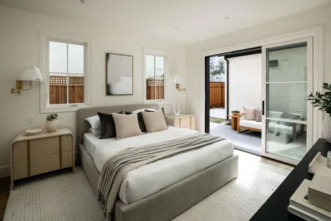 a bedroom with a balcony a bed and a walk in closet