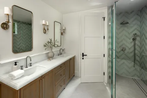 a bathroom with a double vanity sink mirror and shower