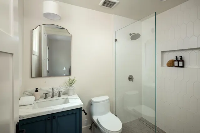 a bathroom with a toilet sink vanity and shower