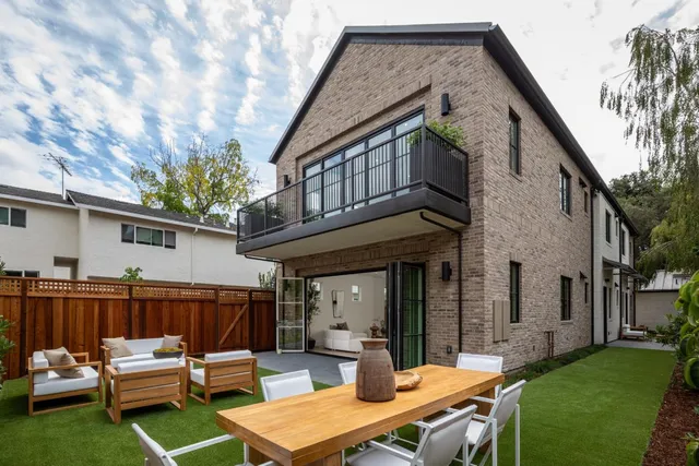 a view of a patio with table and chairs and wooden fence