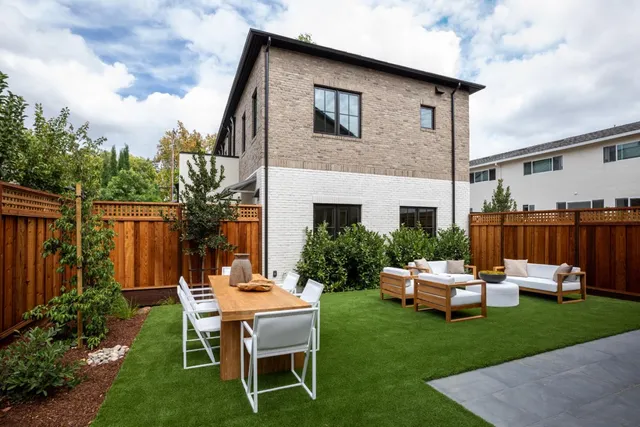 a backyard of a house with a patio table and chairs