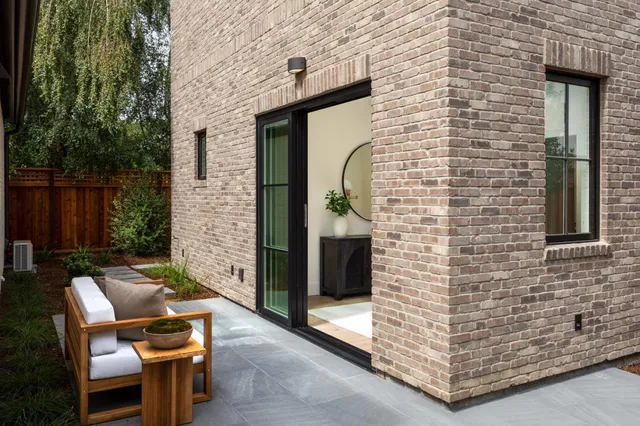 a brick building with a bench and a potted plant