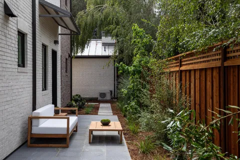 a view of backyard of house with outdoor seating and green space