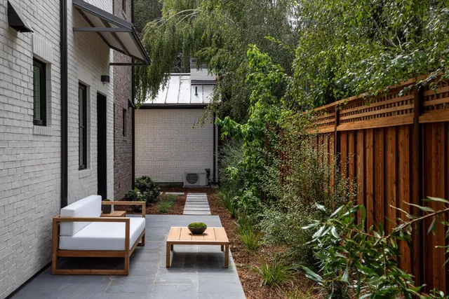 a view of backyard of house with outdoor seating and green space