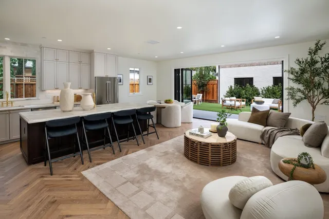 a living room with furniture kitchen view and a large window