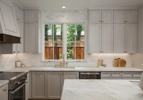 a kitchen with granite countertop white cabinets and window