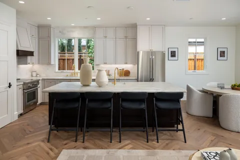 a kitchen with stainless steel appliances granite countertop a table chairs sink refrigerator and microwave