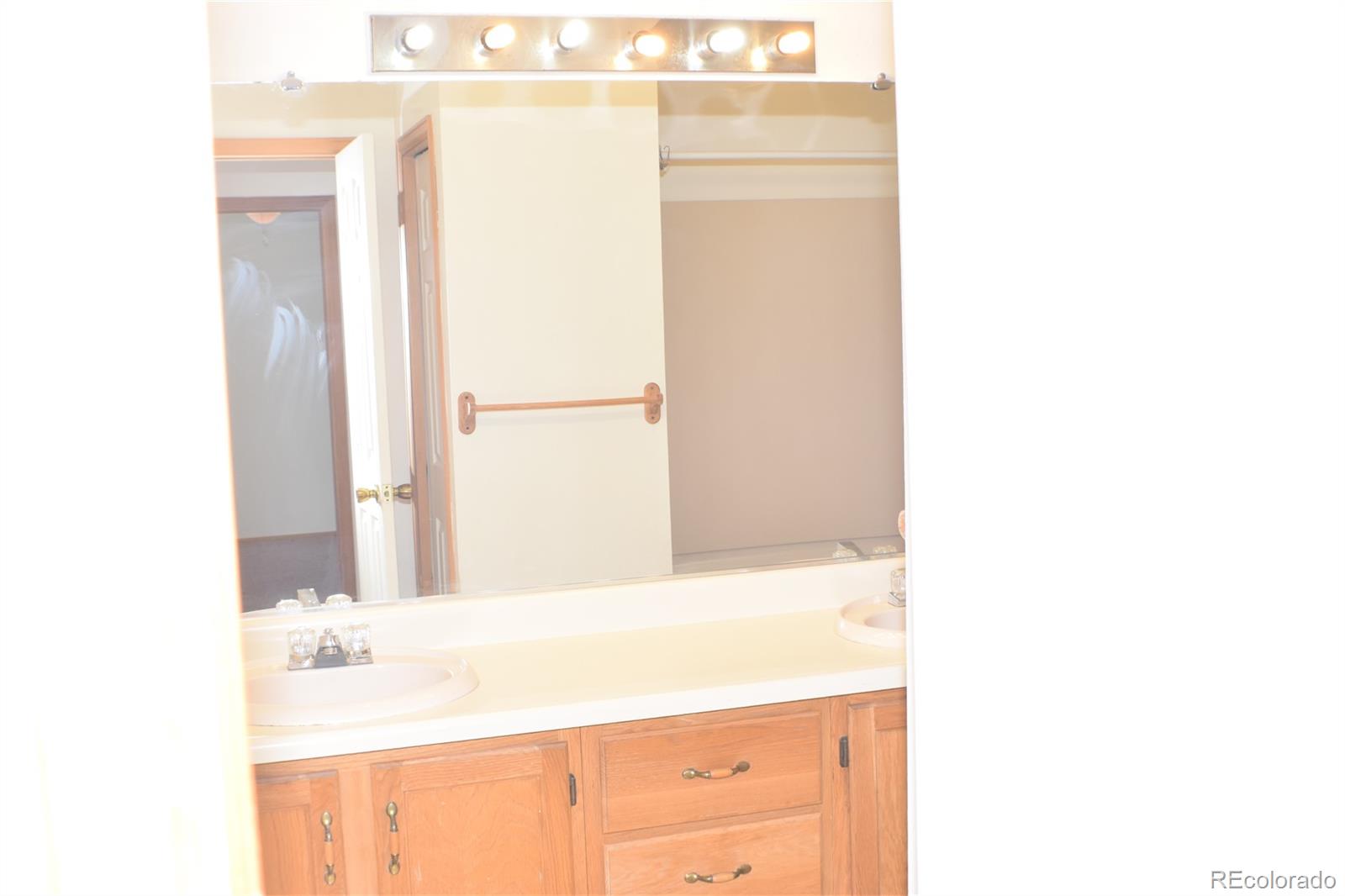 1322 Talley Circle Colorado Springs, CO 80904 - Photo 18 of 32 a bathroom with a sink a mirror and a shower