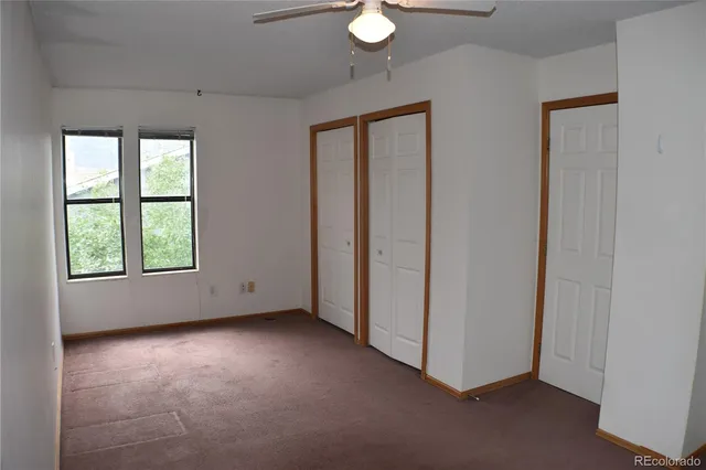 an empty room with windows and closet