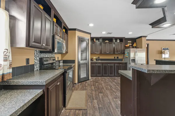 a kitchen with stainless steel appliances granite countertop a refrigerator a stove top oven a sink and dishwasher