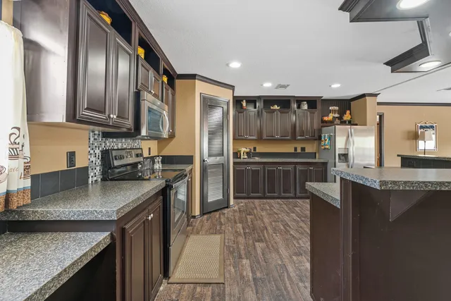 a kitchen with stainless steel appliances granite countertop a refrigerator a stove top oven a sink and dishwasher