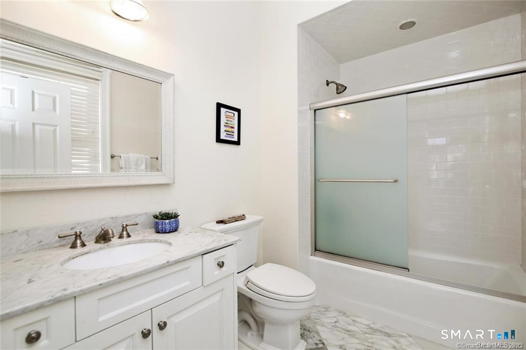 1241 Post Road Fairfield, CT 06824 - Photo 10 of 13 a bathroom with a granite countertop sink toilet and shower