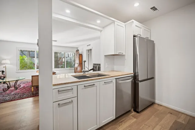 a kitchen with a sink cabinets stainless steel appliances and a window