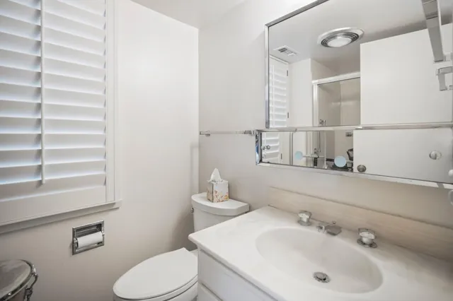 a bathroom with a sink mirror and toilet
