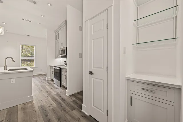 a kitchen with cabinets and wooden floor