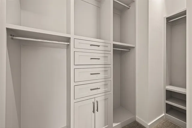 a view of walk in closet with empty racks