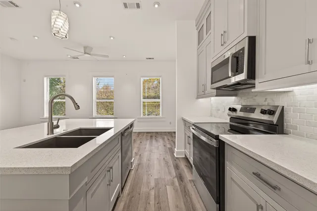 a kitchen with stainless steel appliances granite countertop a sink a stove and microwave