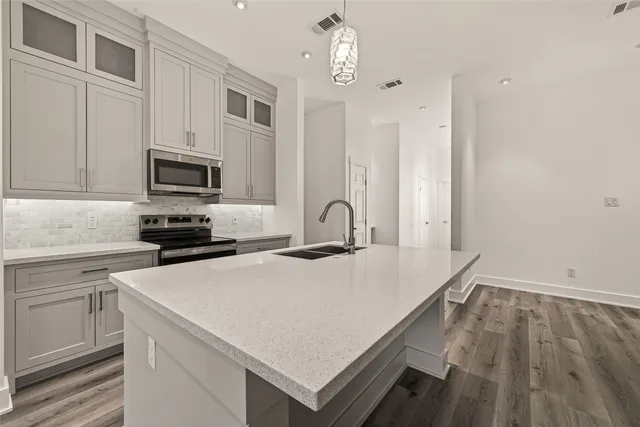 a kitchen with a appliances a sink and cabinets