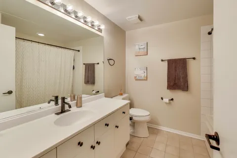 a bathroom with a double vanity sink toilet and mirror