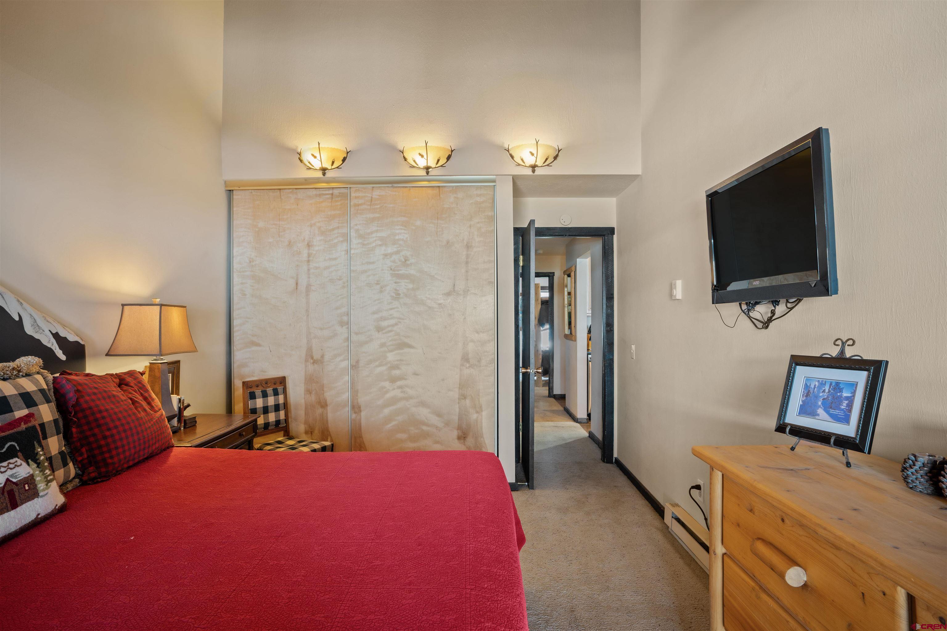 16 Hunter Hill Road, Unit K303 Crested Butte, CO 81225 - Photo 9 of 33 a bedroom with a bed and a flat screen tv