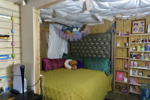 a bed room with a bed and a flat tv screen