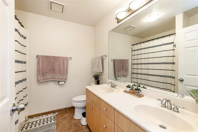 a bathroom with a sink double vanity and a toilet