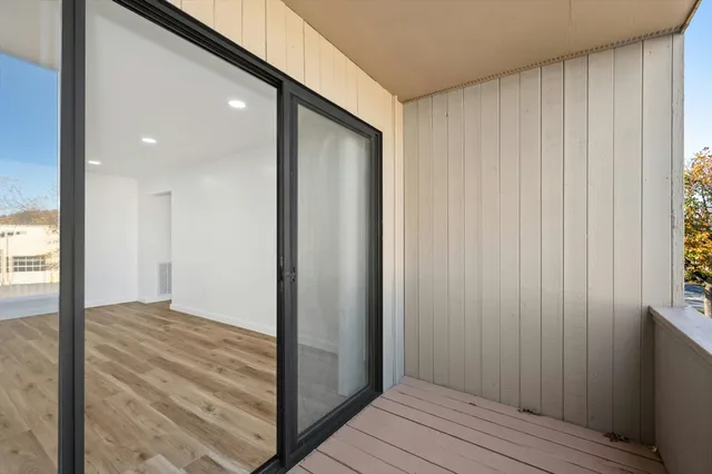 a view of a hallway with wooden floor and staircase