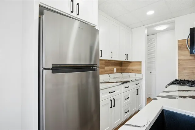 a kitchen with cabinets and a refrigerator