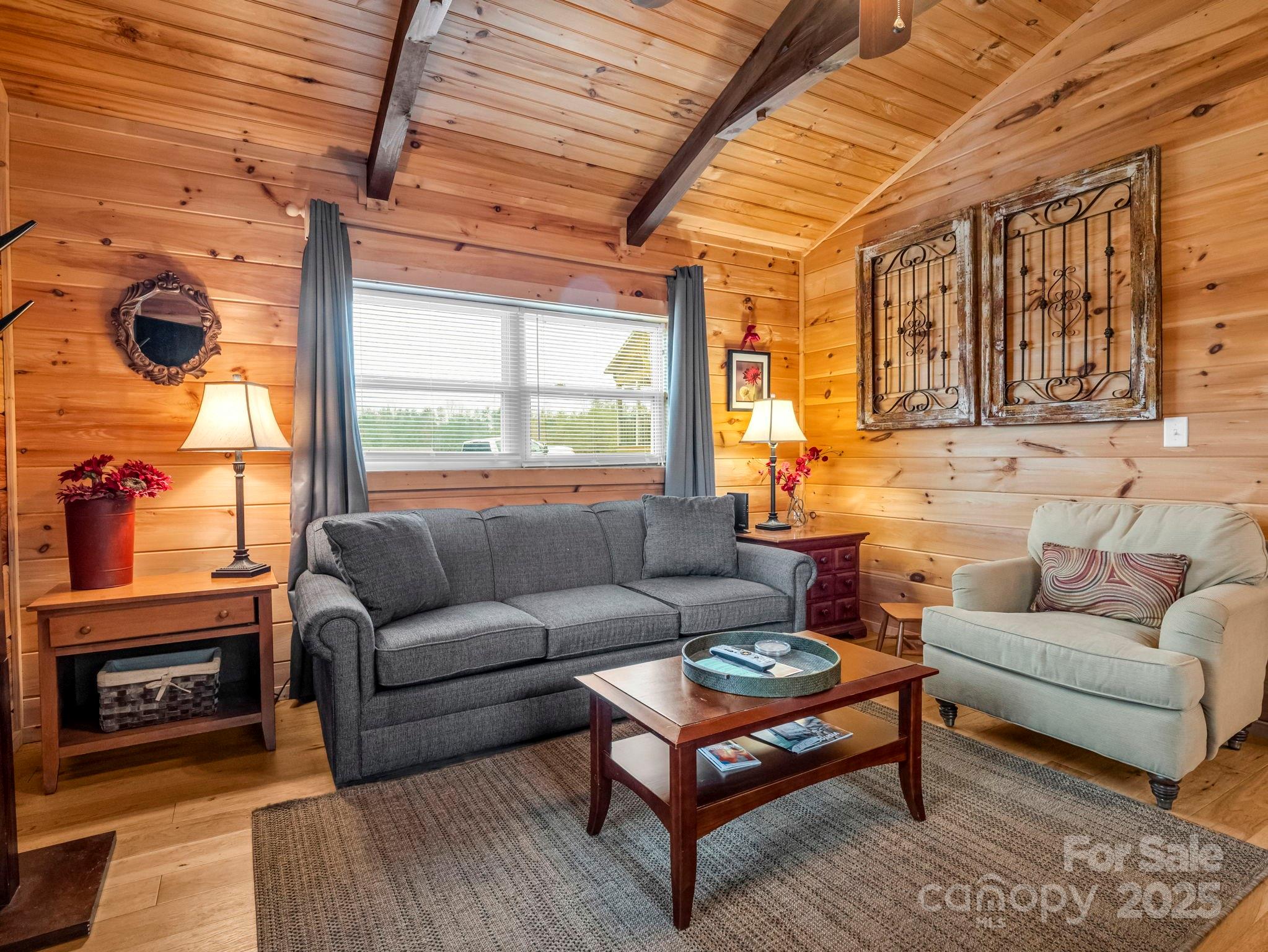 1217 Moore Road, Unit 70 80 & 90 Tryon, NC 28782 - Photo 12 of 42 a living room with furniture a flat screen tv and a floor to ceiling window